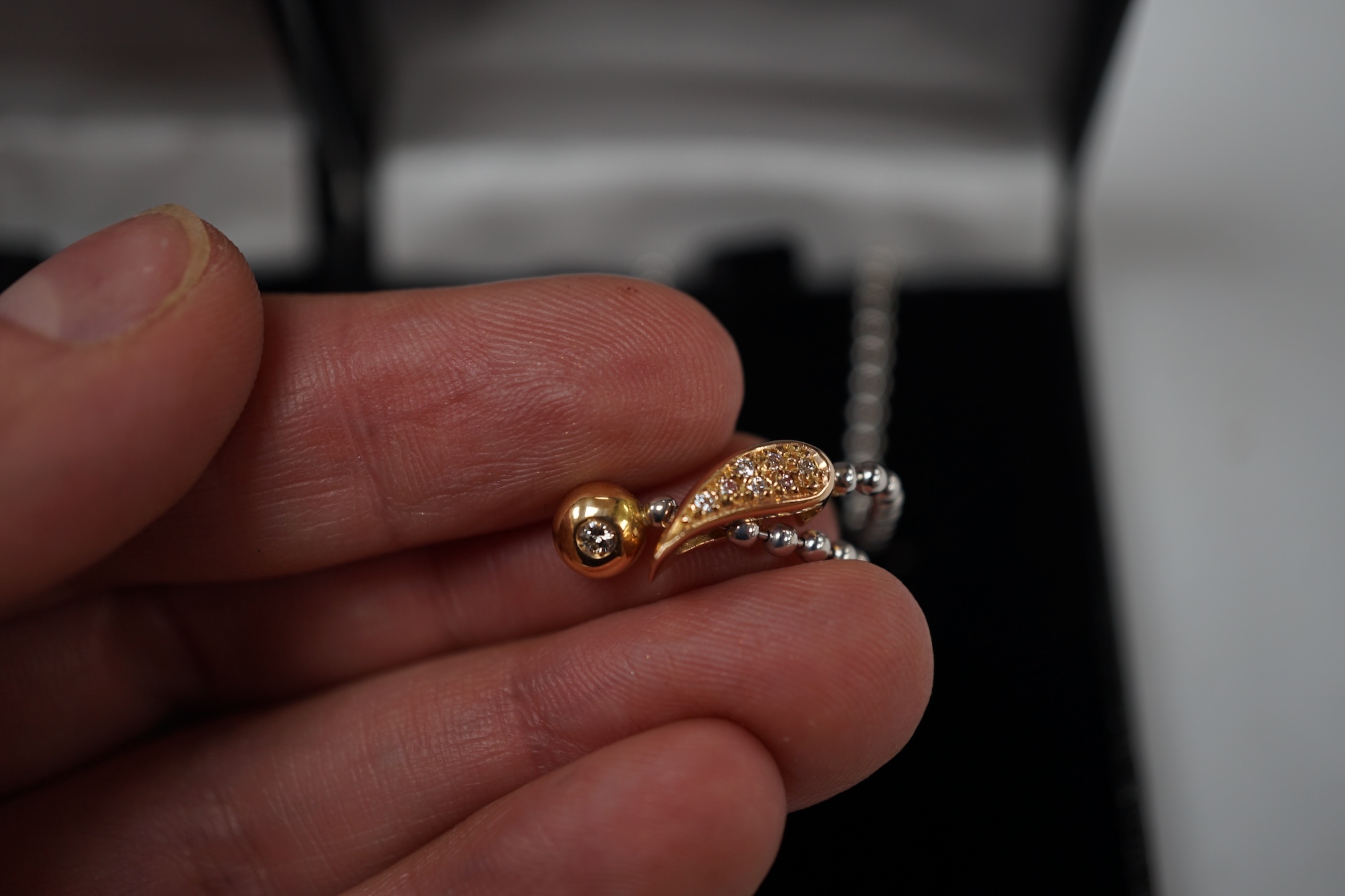 A modern white metal (stamped pt850) and diamond cluster set pendant necklace, 42cm, gross weight 6.3 grams, together with a modern 750 and diamond cluster set pendant, on a white metal ball link chain, 48cm. Condition -